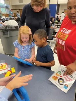 Girl and boy children share a Seedling educational touchpad