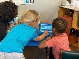 Girl and boy interact with Seedling educational tablet.